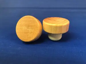 Two Natural Varnished 42x15/24.2 knobs on a blue background.