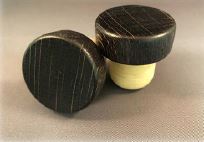 Two Antique Black 34x14/22.5 wine stoppers on a grey surface.