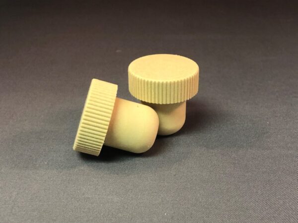 Two beige EN Monobloc 29x10/19.5 plastic knobs on a grey surface.