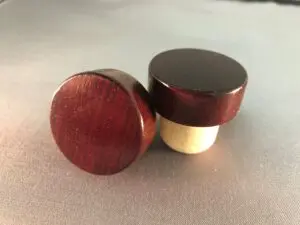 Two Dark Mahogany Glossy 34x14/22.5 wine stoppers on a table.