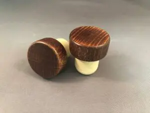 Two Red Mahogany 29x13/19.5 wine stoppers on a grey surface.
