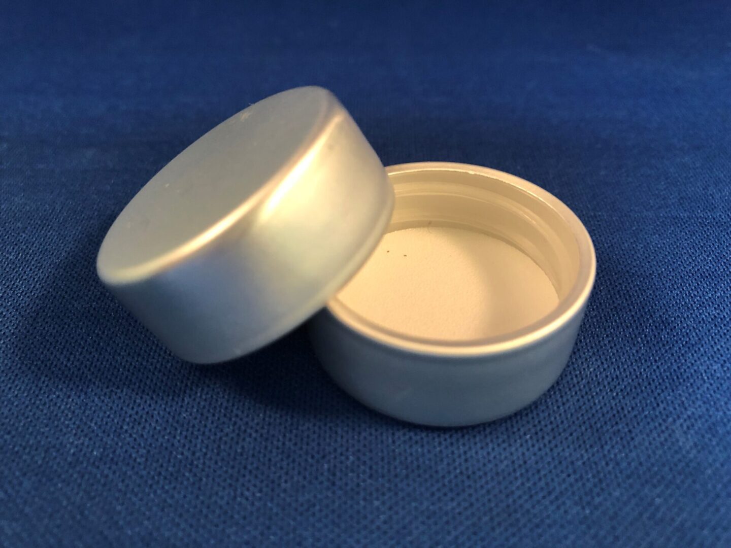 A white plastic Silver SCR 33-400 container with a lid on a blue background.