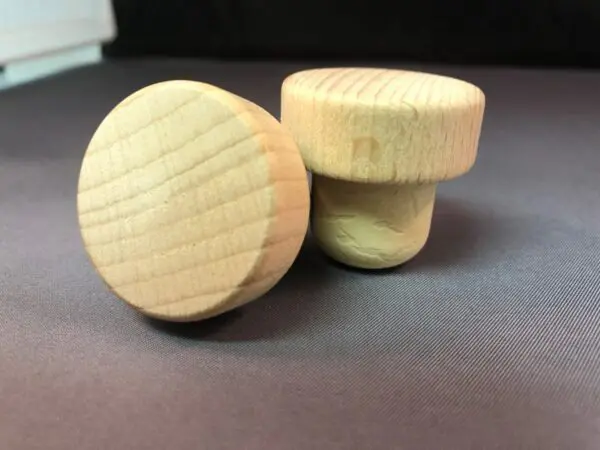 A pair of Unvarnished 34x14/22.5 wine stoppers on a table.