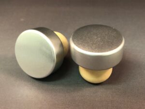 A pair of Silver Starcap 33x14/22.5 knobs on a black surface.